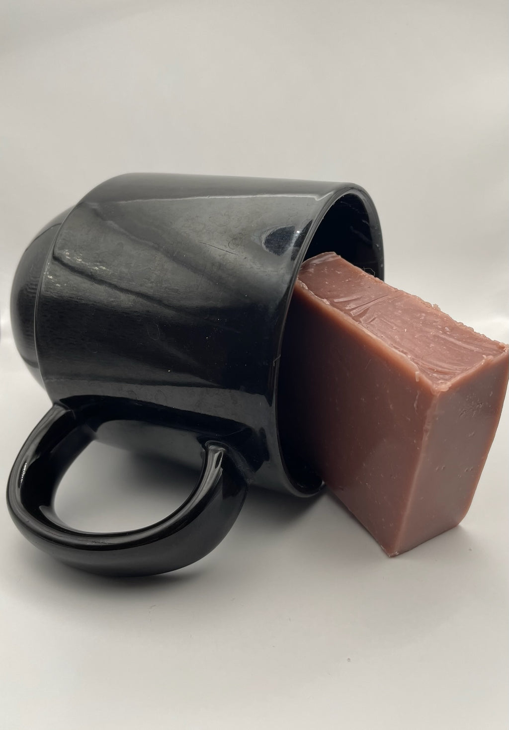 The Tea soap bar resting against a black ceramic mug