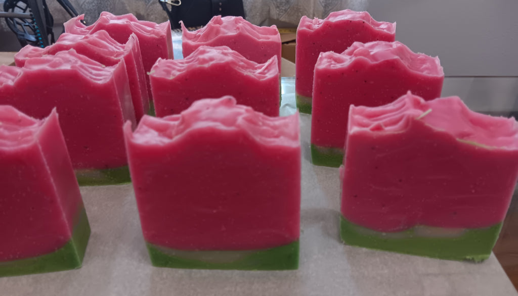 Watermelon soap bars with vibrant pink tops and green bases, cold-process artisan soap