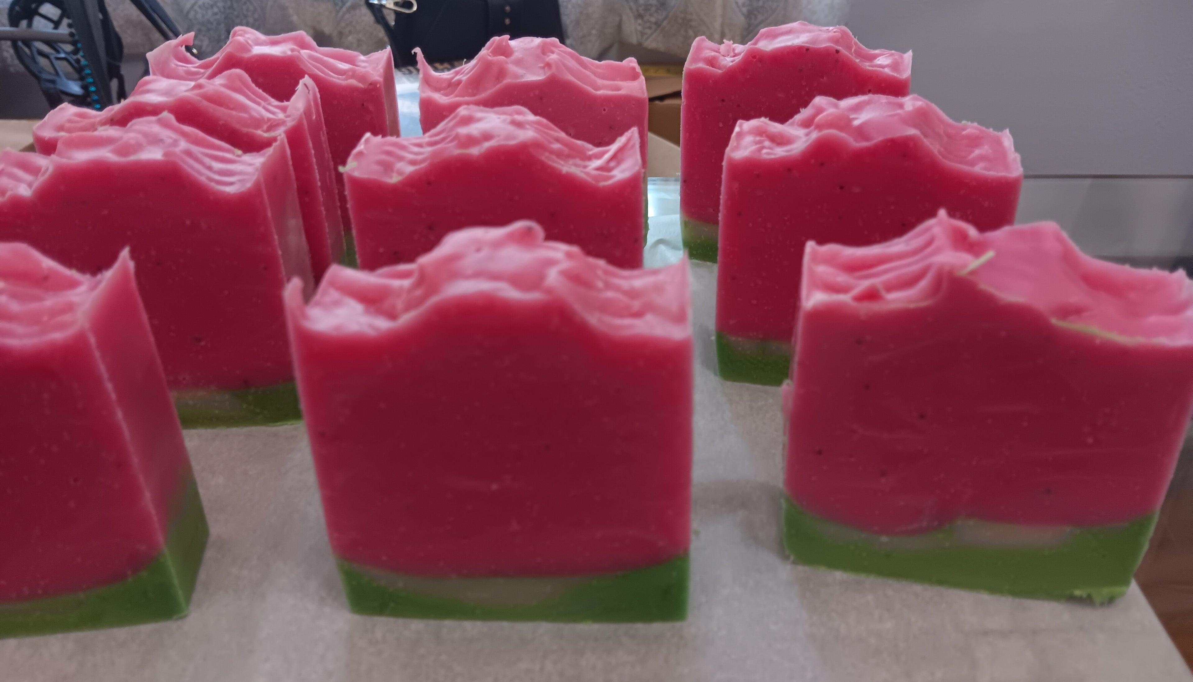 Watermelon soap bars with vibrant pink tops and green bases, cold-process artisan soap