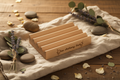 Alder wood soap dish styled on warm linen with dried botanicals and smooth stones