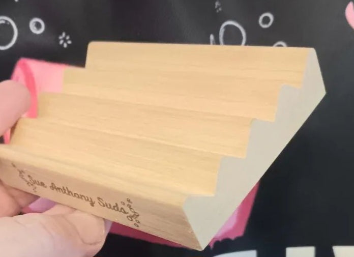 Alder wood soap dish with ridged drainage design, laser-engraved with Sue Anthony Suds branding